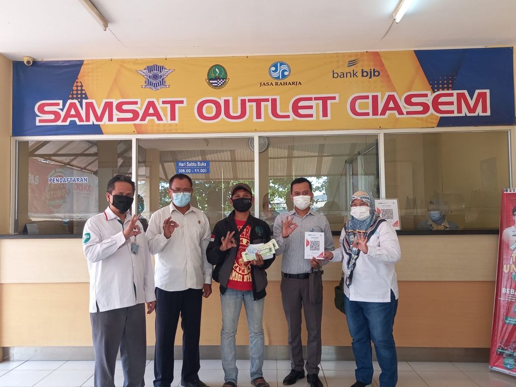 Salah satu wajib pajak dari Ciasem Subang, Hery Anwar (bertopi) membayar pajak motor di outlet Samsat Ciasem dengan penggunaan QRIS. (Foto: P3DW Subang)